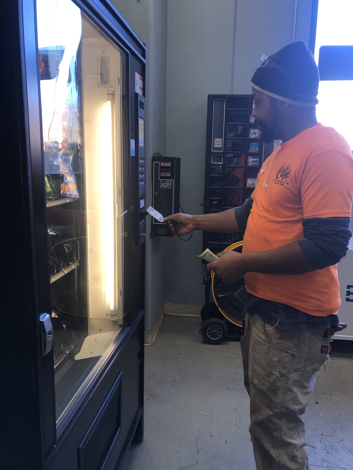 A man inserting money on the vending machine